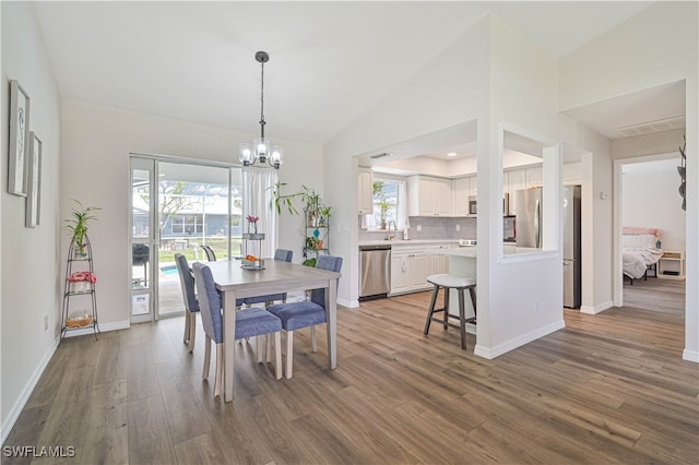 dining space featuring hardwood / wood-style flooring, plenty of natural light, a notable chandelier, and sink