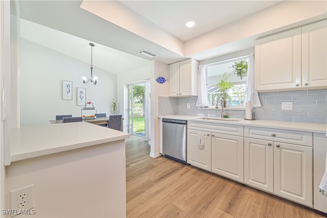 kitchen featuring plenty of natural light, stainless steel dishwasher, sink, and light hardwood / wood-style floors