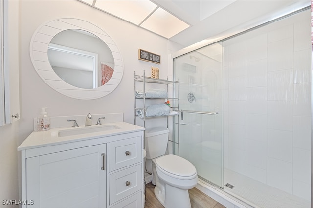 bathroom featuring an enclosed shower, hardwood / wood-style floors, toilet, and vanity