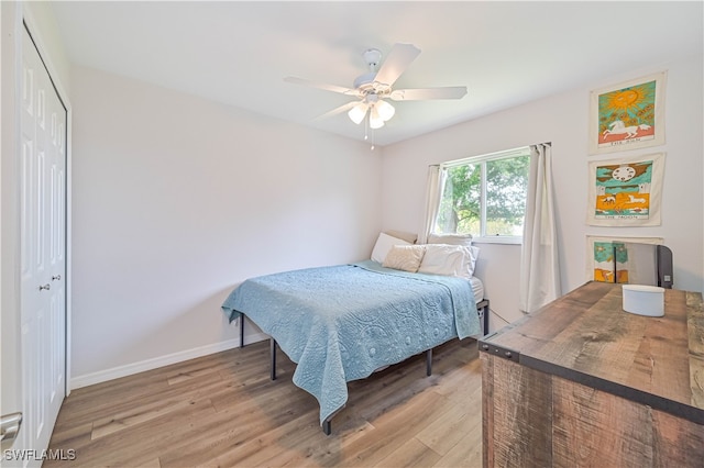 bedroom featuring light wood-type flooring, ceiling fan, and a closet