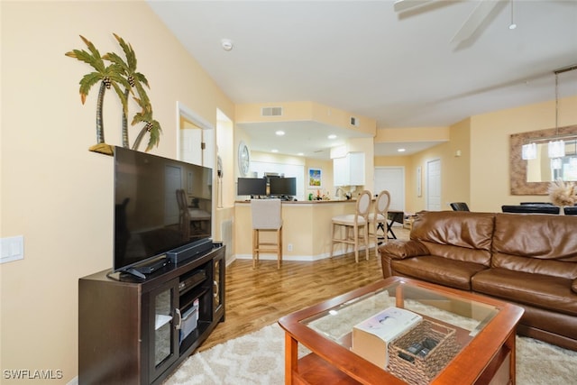 living room featuring ceiling fan and light hardwood / wood-style floors