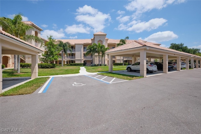 view of parking featuring a yard and a carport