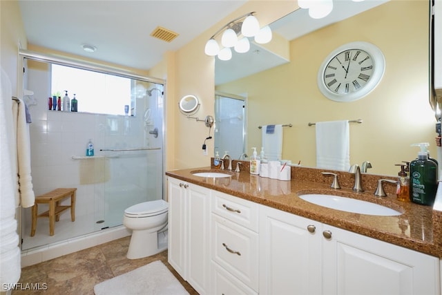 bathroom with vanity, toilet, and a shower with door