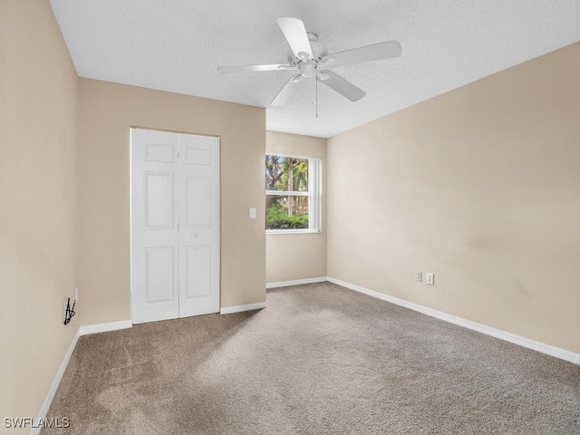 unfurnished bedroom featuring a closet, ceiling fan, carpet, and a textured ceiling