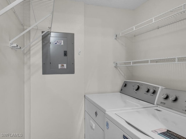 laundry room with electric panel and washer and clothes dryer