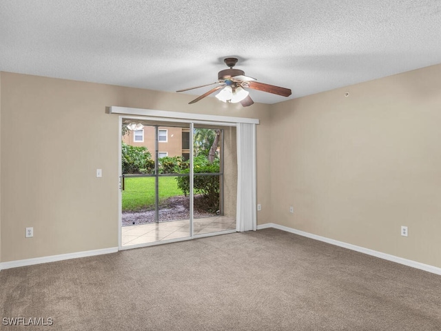 carpeted spare room featuring a textured ceiling and ceiling fan