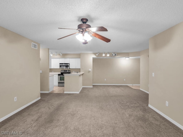 unfurnished living room featuring a textured ceiling, ceiling fan, light carpet, and track lighting