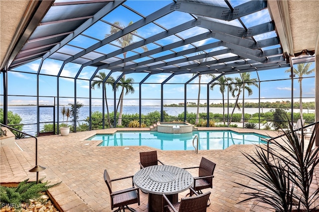 view of pool with a patio area, an in ground hot tub, glass enclosure, and a water view