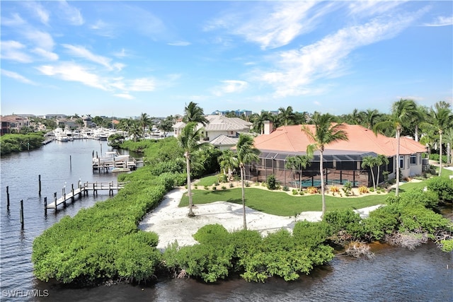 dock area featuring a water view, a lawn, and a lanai