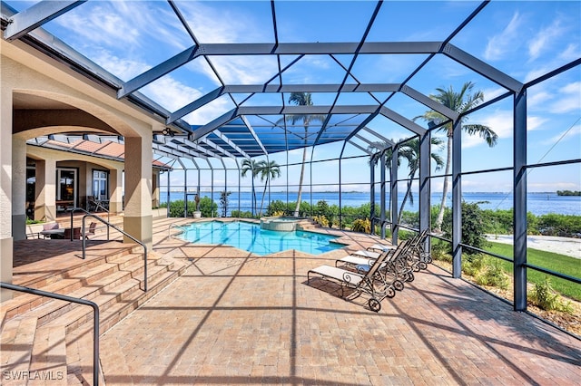 view of swimming pool featuring a patio area, glass enclosure, and a water view