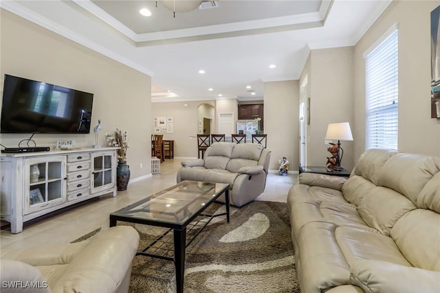 living area featuring baseboards, ornamental molding, a raised ceiling, and light tile patterned flooring