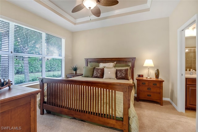 bedroom with ceiling fan, connected bathroom, light colored carpet, baseboards, and a raised ceiling