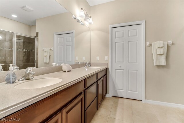 bathroom with a stall shower, tile patterned flooring, a sink, and double vanity