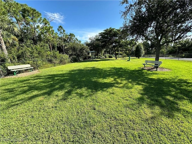 view of home's community featuring a lawn and fence