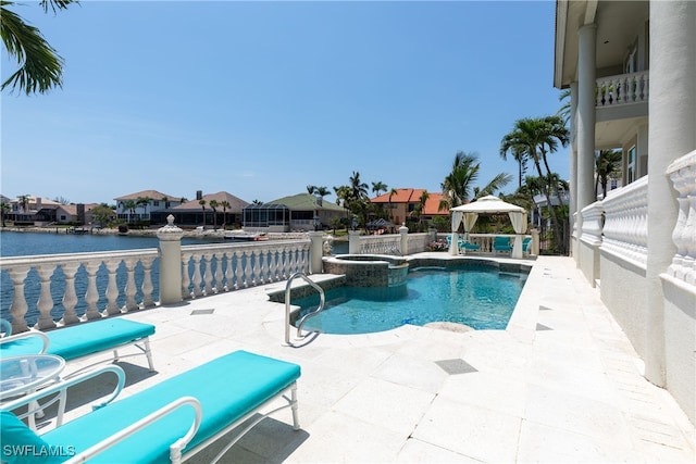 view of pool featuring a water view, a patio area, a gazebo, and an in ground hot tub