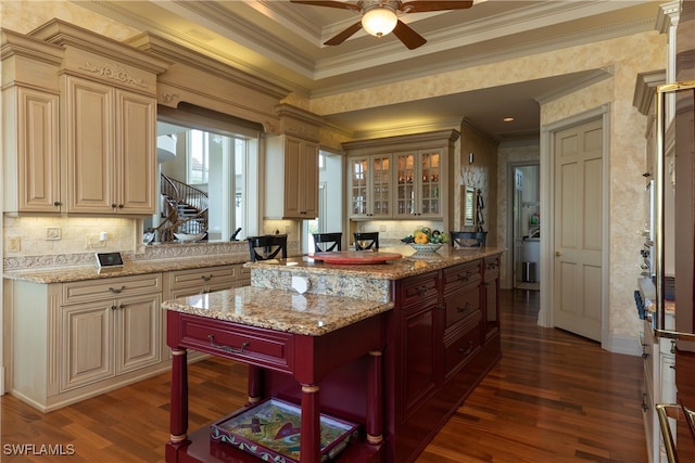 kitchen featuring crown molding, ceiling fan, and light stone countertops