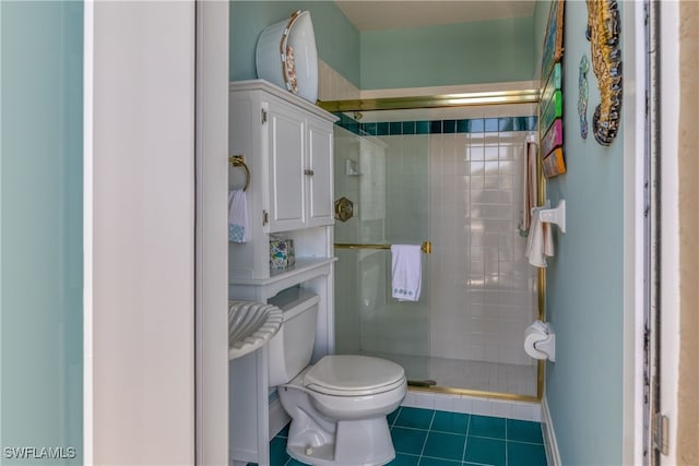 bathroom with toilet, tile patterned floors, and a shower with door