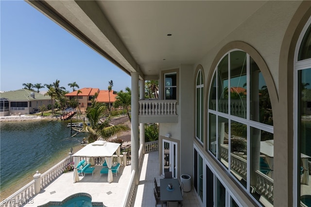 balcony featuring a water view and a patio