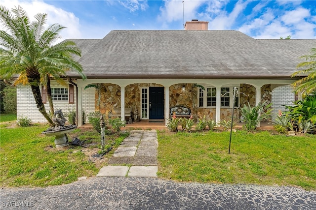 view of front of house with covered porch and a front yard