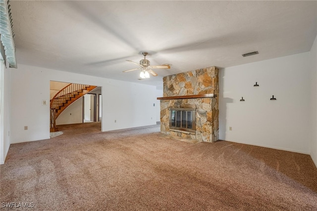 unfurnished living room featuring carpet, ceiling fan, and a stone fireplace