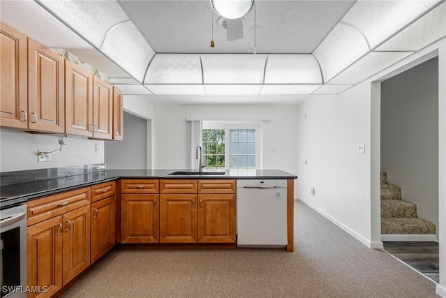 kitchen featuring white dishwasher, light colored carpet, sink, kitchen peninsula, and ceiling fan