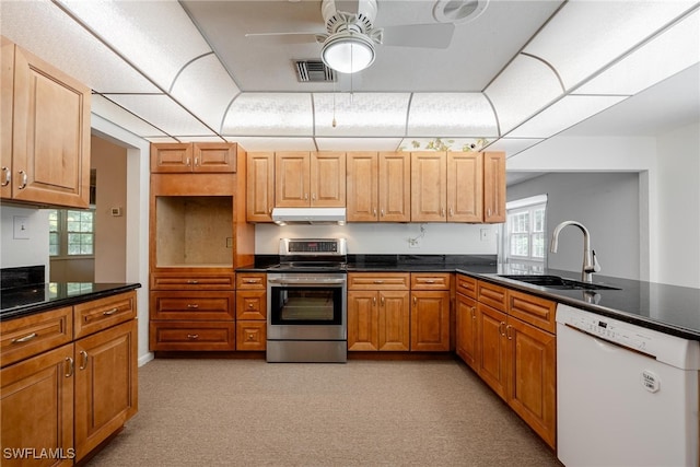 kitchen featuring stainless steel range, dishwasher, sink, ceiling fan, and light colored carpet