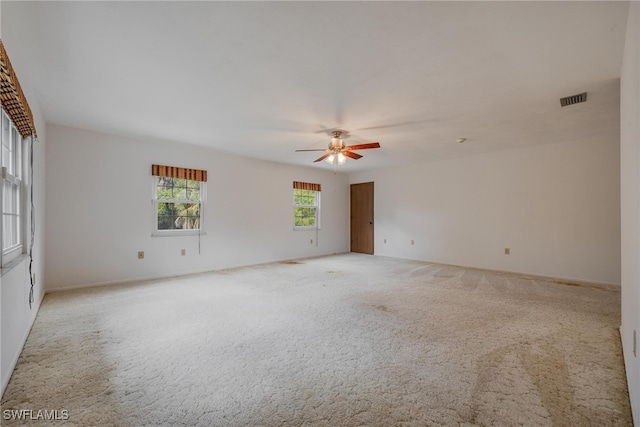 carpeted spare room with ceiling fan