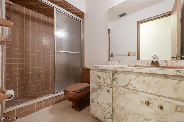 bathroom with a shower with shower door, toilet, and vanity