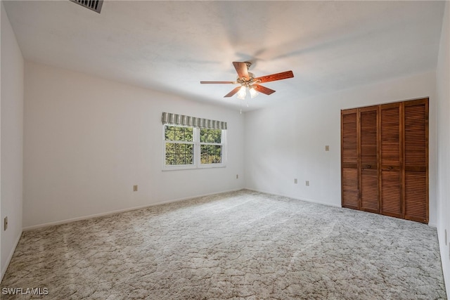 unfurnished bedroom with ceiling fan, a closet, and carpet floors