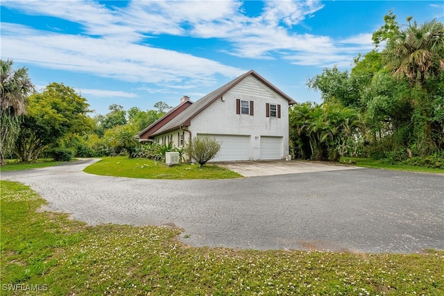 view of side of property featuring a garage and central air condition unit