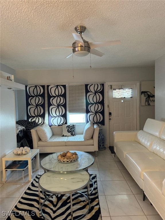 tiled living room featuring ceiling fan and a textured ceiling