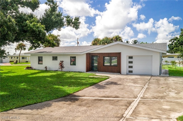 view of front of home featuring a shingled roof, concrete driveway, a front yard, stucco siding, and a garage