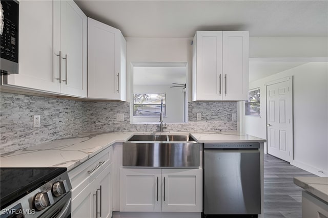 kitchen with sink, ceiling fan, decorative backsplash, appliances with stainless steel finishes, and white cabinetry