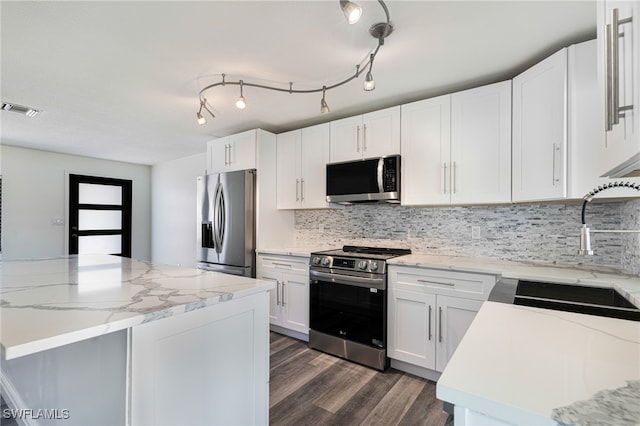 kitchen with visible vents, a sink, decorative backsplash, stainless steel appliances, and dark wood-style flooring