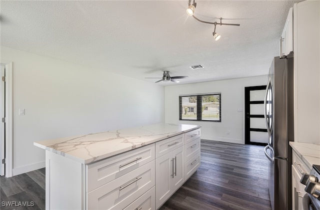 kitchen featuring ceiling fan, dark wood-type flooring, freestanding refrigerator, and a center island