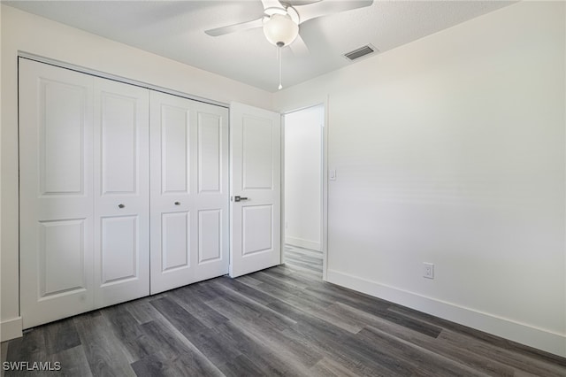 unfurnished bedroom featuring visible vents, baseboards, a closet, dark wood-style floors, and a ceiling fan