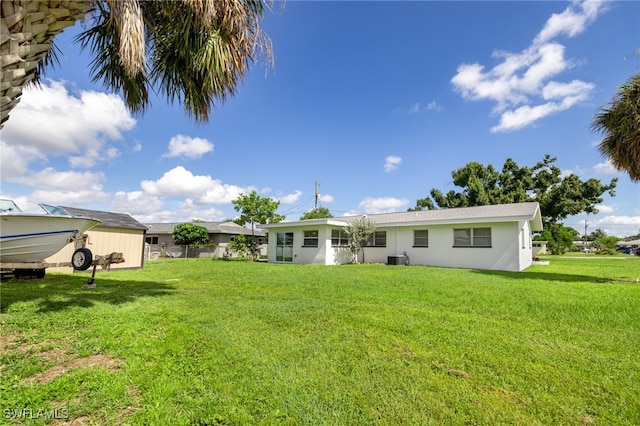 back of property with cooling unit and a lawn