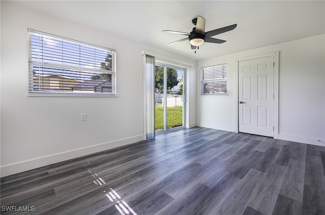 unfurnished room featuring dark wood finished floors, a ceiling fan, and baseboards