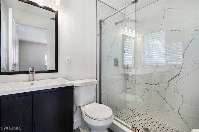 bathroom featuring vanity, toilet, and a shower with shower door