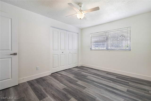 unfurnished bedroom featuring ceiling fan, a closet, dark hardwood / wood-style floors, and a textured ceiling