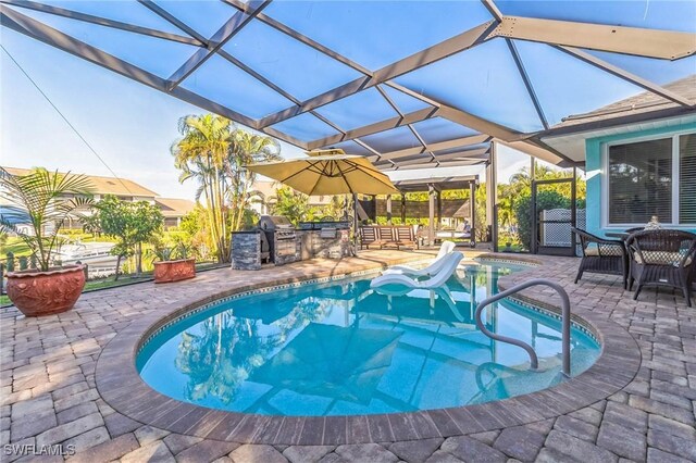 view of swimming pool with a patio, an outdoor kitchen, a grill, and glass enclosure