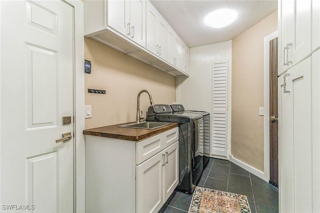 laundry area featuring cabinets, sink, washing machine and clothes dryer, and dark tile patterned flooring