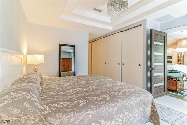 bedroom featuring a tray ceiling and a closet