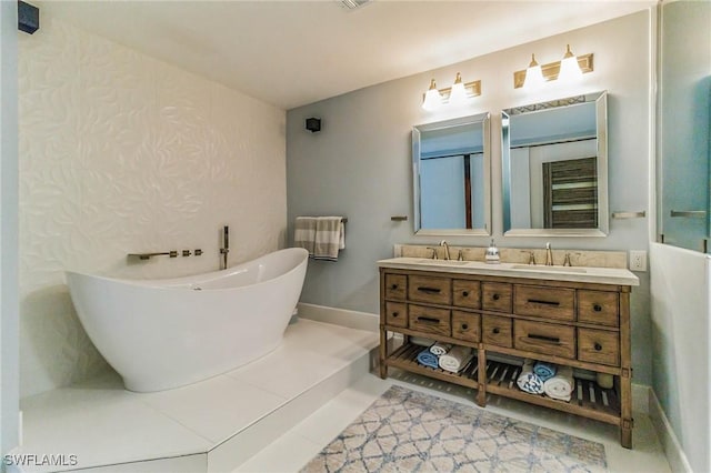 full bath with double vanity, a freestanding tub, baseboards, and a sink