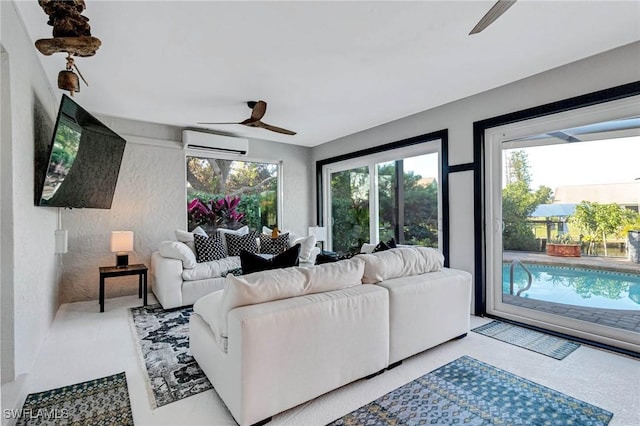 living room with a ceiling fan and a wall unit AC