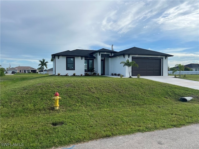 view of front of house featuring a garage and a front lawn