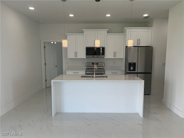 kitchen with sink, appliances with stainless steel finishes, white cabinetry, and a kitchen island with sink