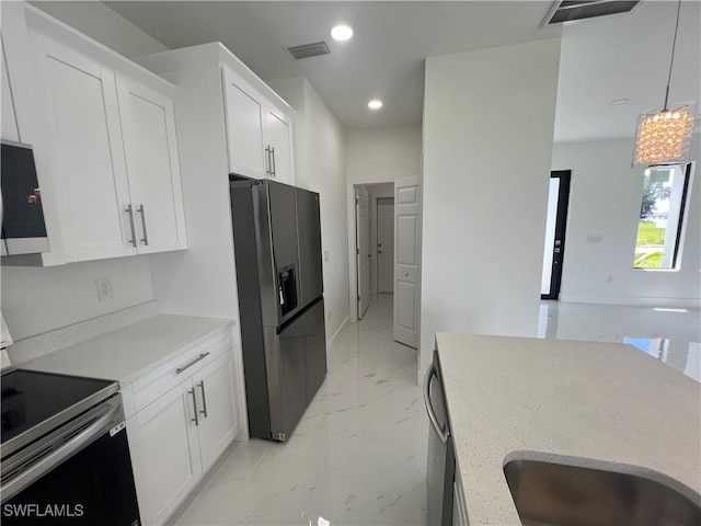 kitchen featuring stainless steel appliances, sink, decorative light fixtures, and white cabinetry