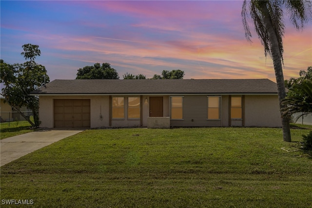 ranch-style house with a yard and a garage