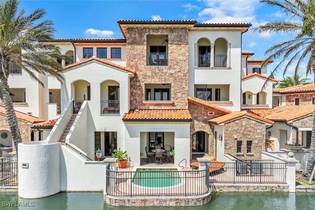 16649 Toscana Cir Unit 803, Naples, FL 34110 - back of house featuring stone siding, a tile roof, stucco siding, and a patio area